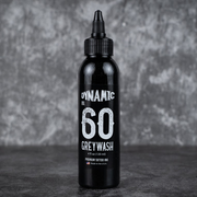 Black bottle of Dynamic Greywash tattoo ink on a gray background