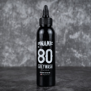 Black bottle of Dynamic No. 80 Grey Wash tattoo ink on a dark background