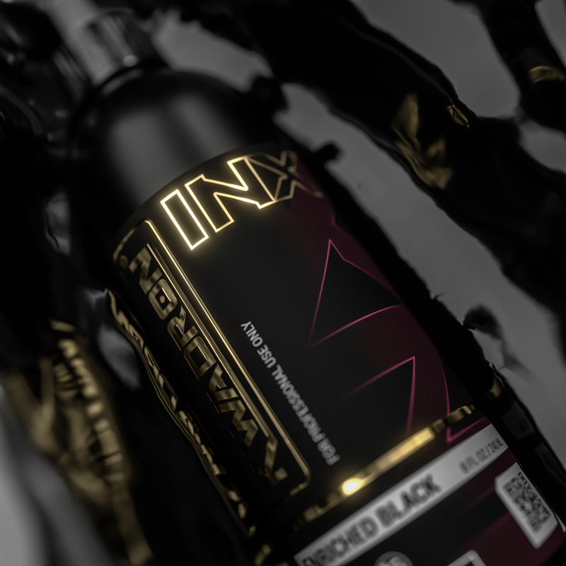 Close-up of a motorcycle with 'INX' branding on a dark background